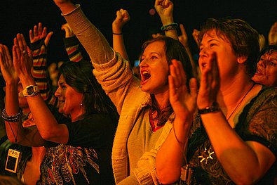 3 Frauen die in die Hände klatschen und jubeln bei Nacht am Donauinselfest