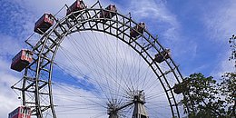 Blauer Himmel mit ein paar Wolken, Wiener Riesenrad, rote Gondeln