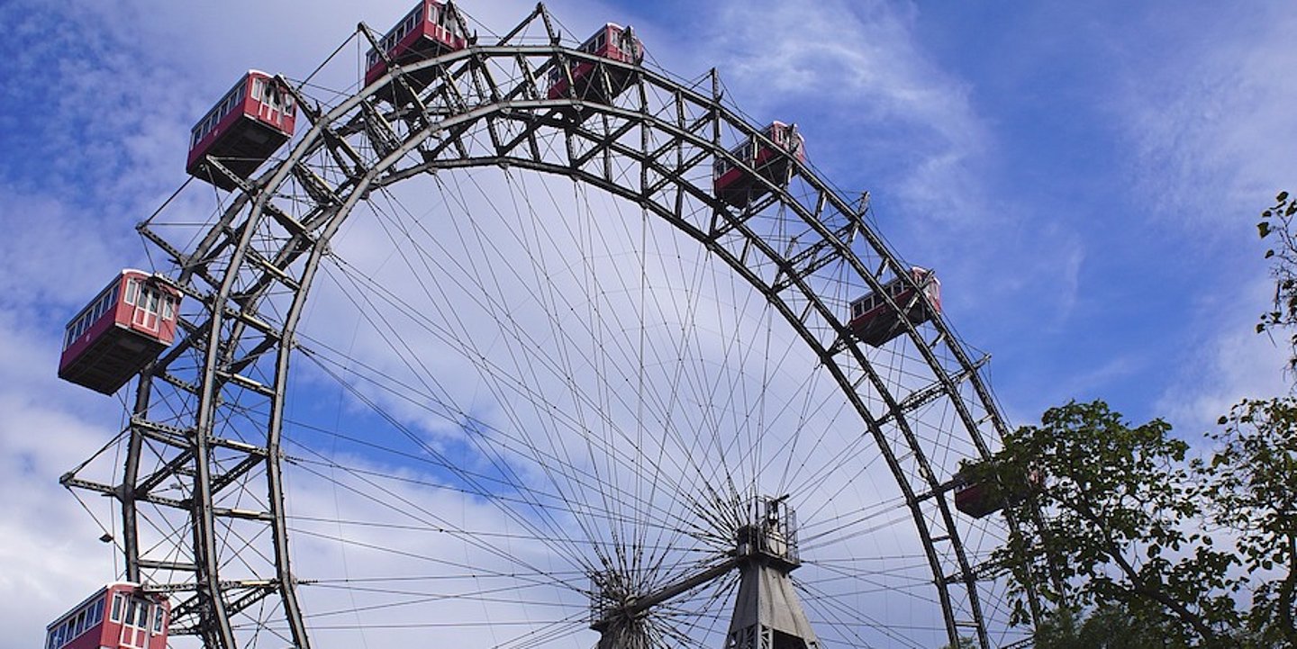 Blauer Himmel mit ein paar Wolken, Wiener Riesenrad, rote Gondeln