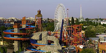 Überblick über den Wiener Prater: im Vordergrund die Wildalpenbahn, im Hintergrund das Riesenrad und andere Attraktionen.