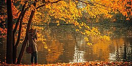 Frau am See in Herbstkulisse