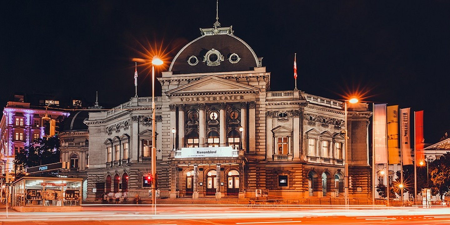 Foto des Volkstheaters bei Nacht.