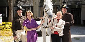 2 Damen jeweils links und rechts von einem Lipizzaner.