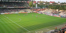 Eine große Stadionwiese von der Tribüne aus gesehen