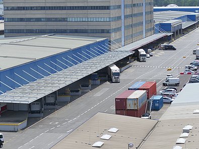 LKWs verlassen die Verladerampe am Hafen Wien