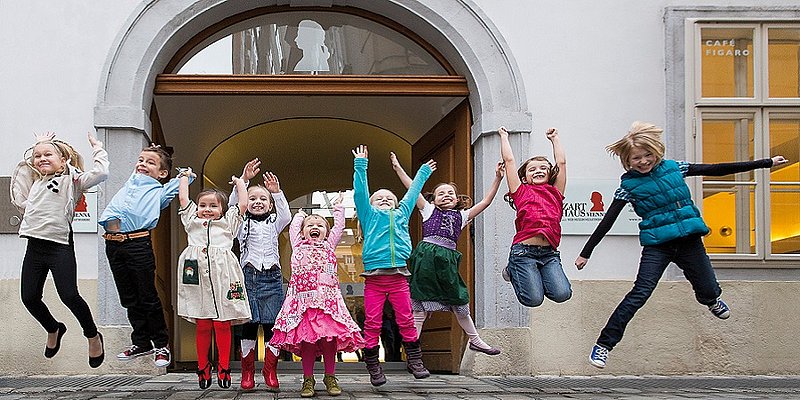 Kinder springen vor dem Mozarthaus 