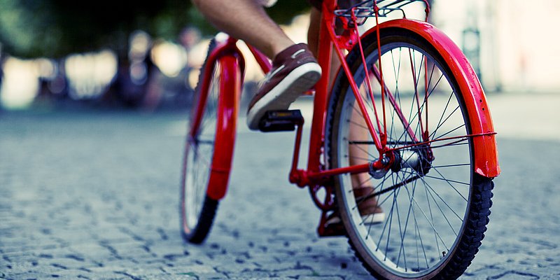 Ein rotes Fahrrad am Asphalt