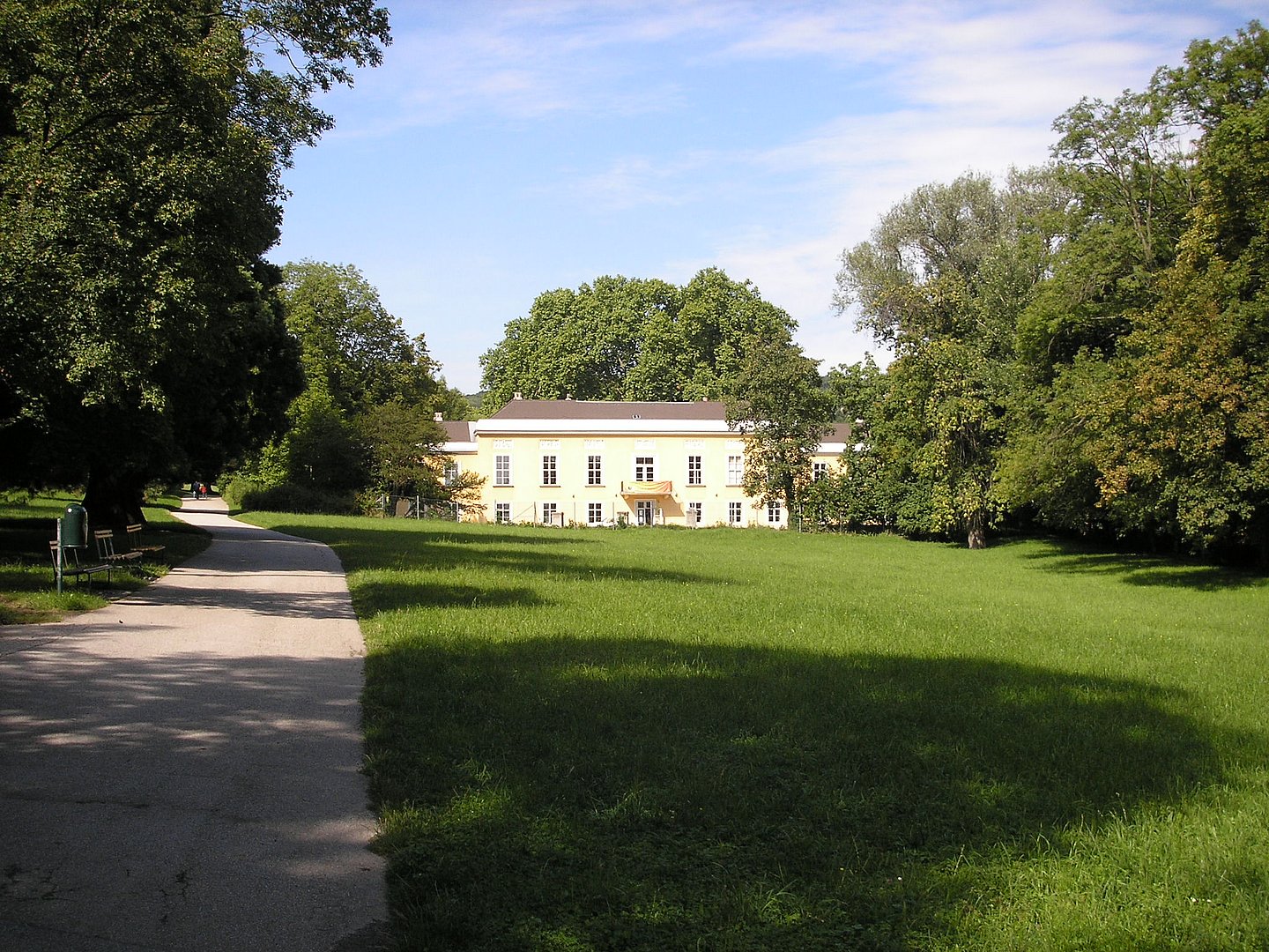 Eine große Wiese vor einem weißen Schloss bei Sonnenschein