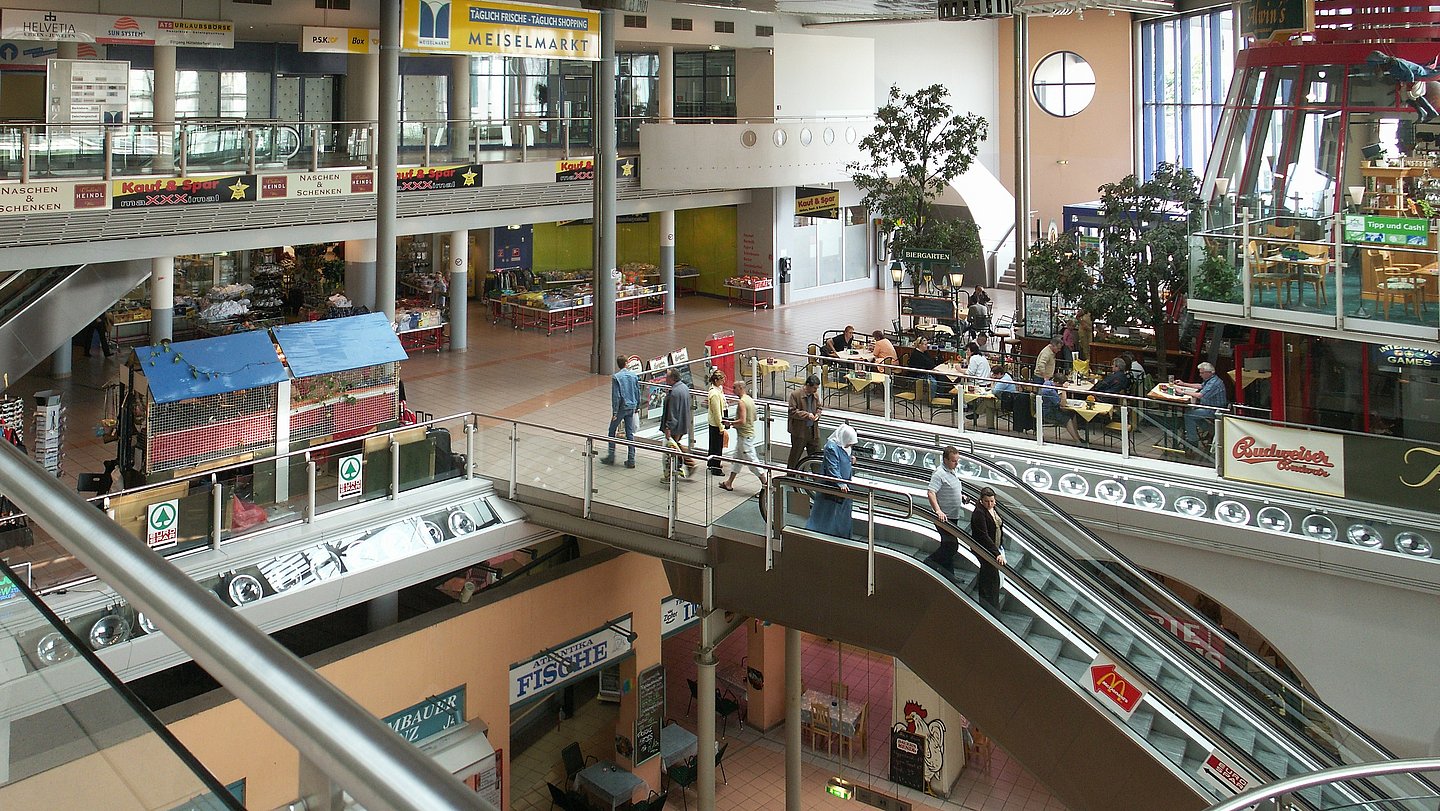 Bild von überdachtem Meiselmarkt: oben Shoppingcenter, unten Markt mit Gemüse und Co.