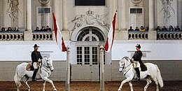 Zwei Bereiter reiten mit ihren Lipizzanern ein Pas de Deux.