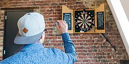 Mann spielt Darts