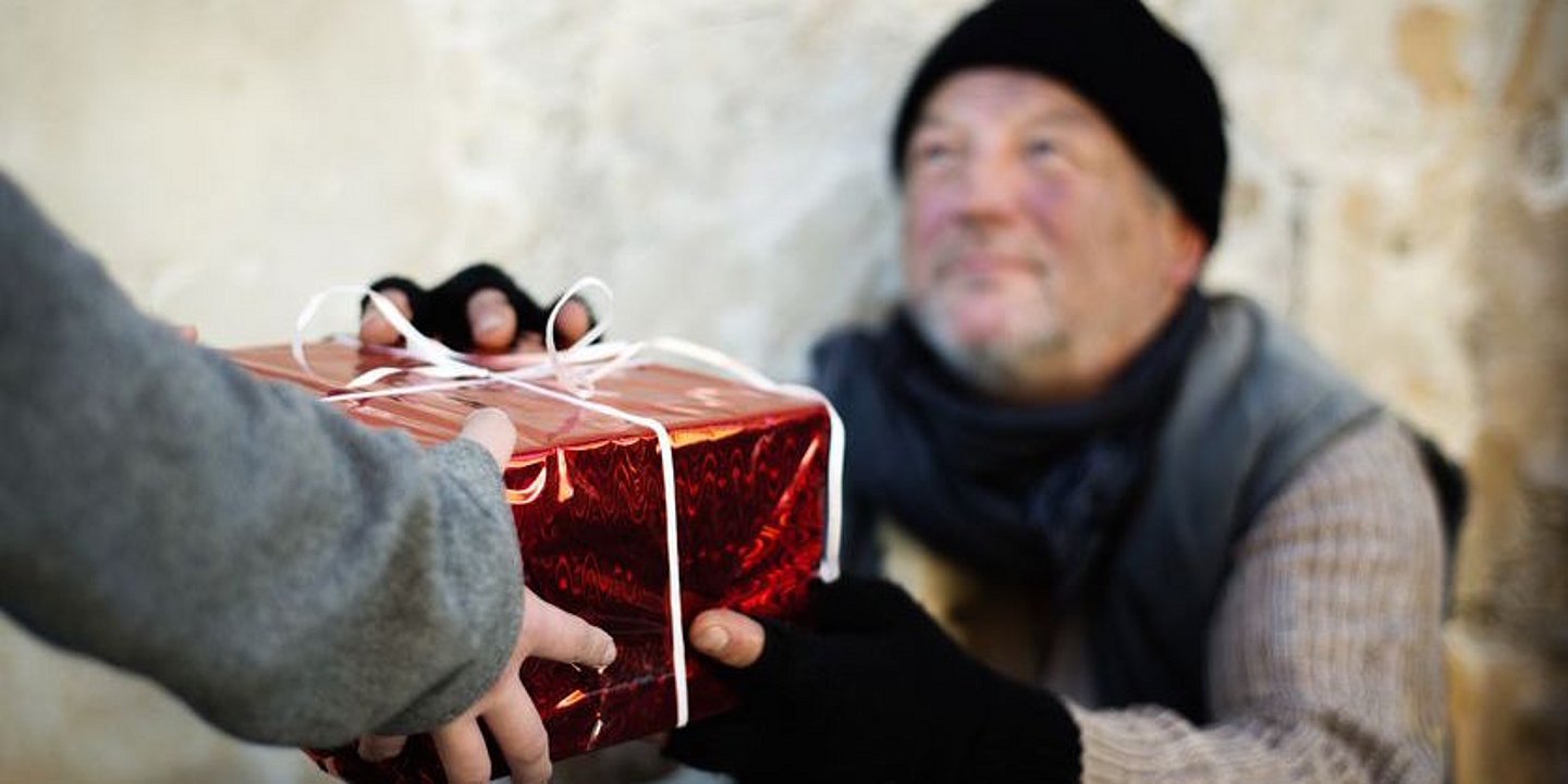 Geschenk überreicht an armen Mann