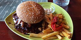 Burger mit Pommes Frites auf grünem Teller