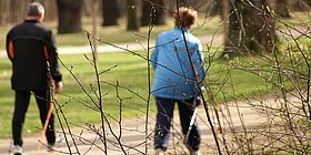 2 Personen mit Gehstöcken im Wald