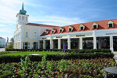 Blick über Grünflächen richtung Designer Outlet Parndorf