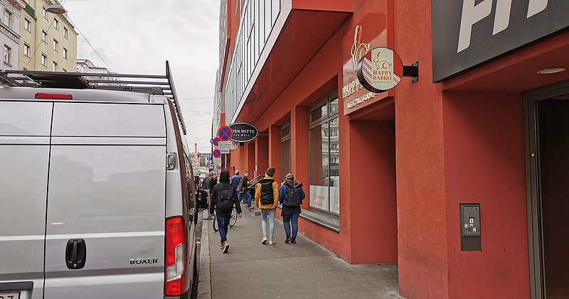 Die rote Fassade eines Restaurants von der Seitenansicht. Ein weißes Schild mit einem Hasen ist an der Seite angebracht