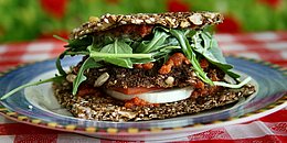 Veganes Brot mit Ruccula und Tomaten gefüllt auf einem Teller angerichtet