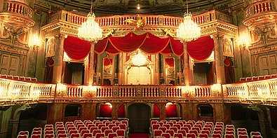 Hell beleuchteter Theatersaal im Schloss Schönbrunn.