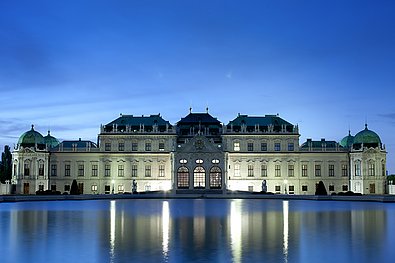 Das Schloss Belveder spiegelt sich abends im Wasser