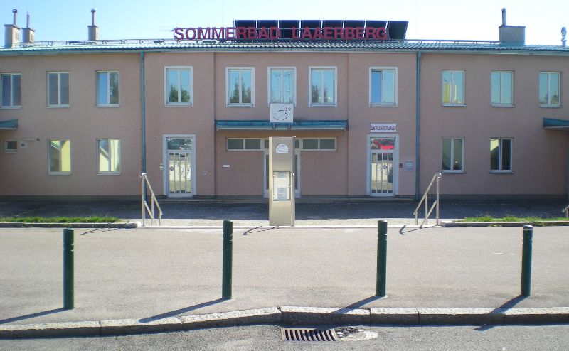 Von der Straße aus gesehen: Eine treppe führt zum Eingang des Laaerbergbad